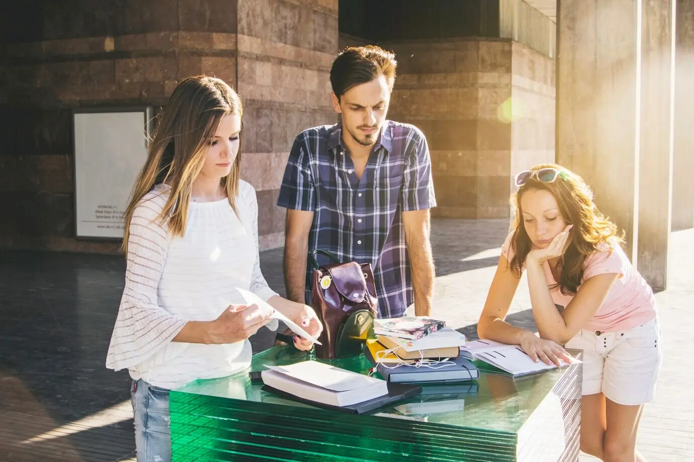 Junge Leute posieren im Freien mit Büchern.